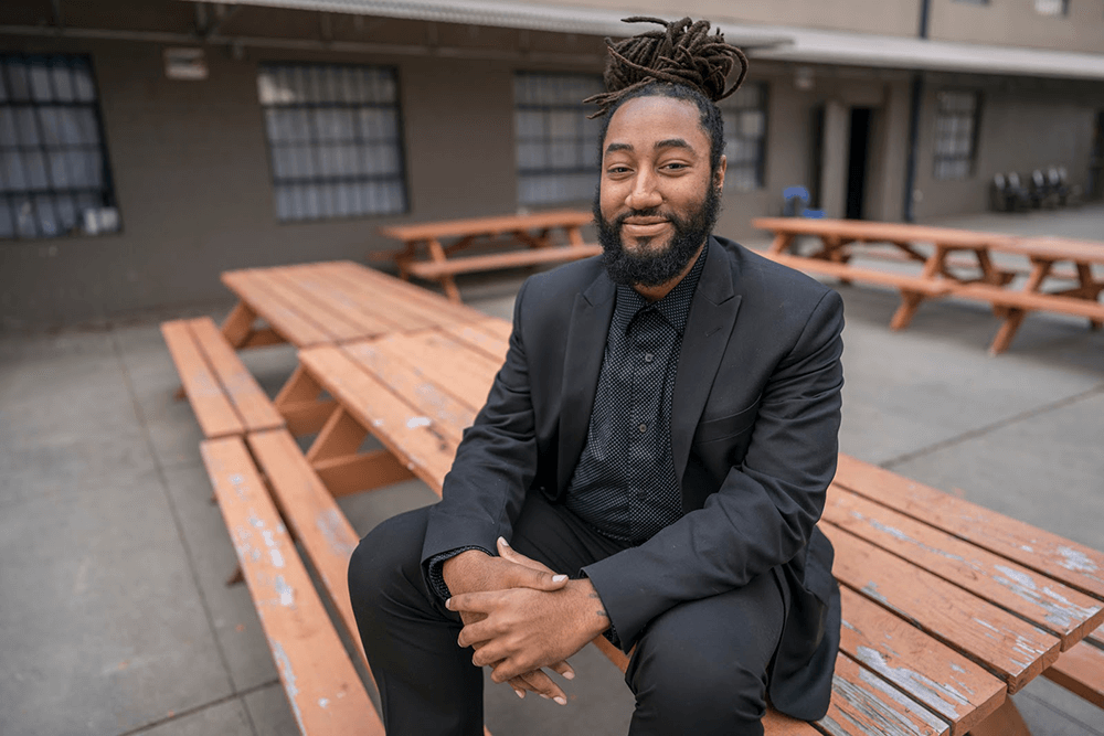 a man who works and an Ambassador at Atlanta Mission sitting on a picnic table