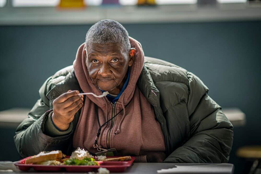 person eating food during Thanksgiving at Atlanta Mission