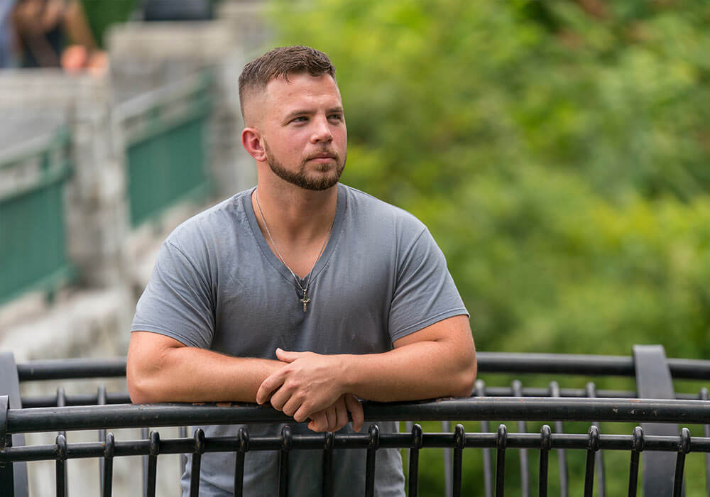 man posing on a bridge