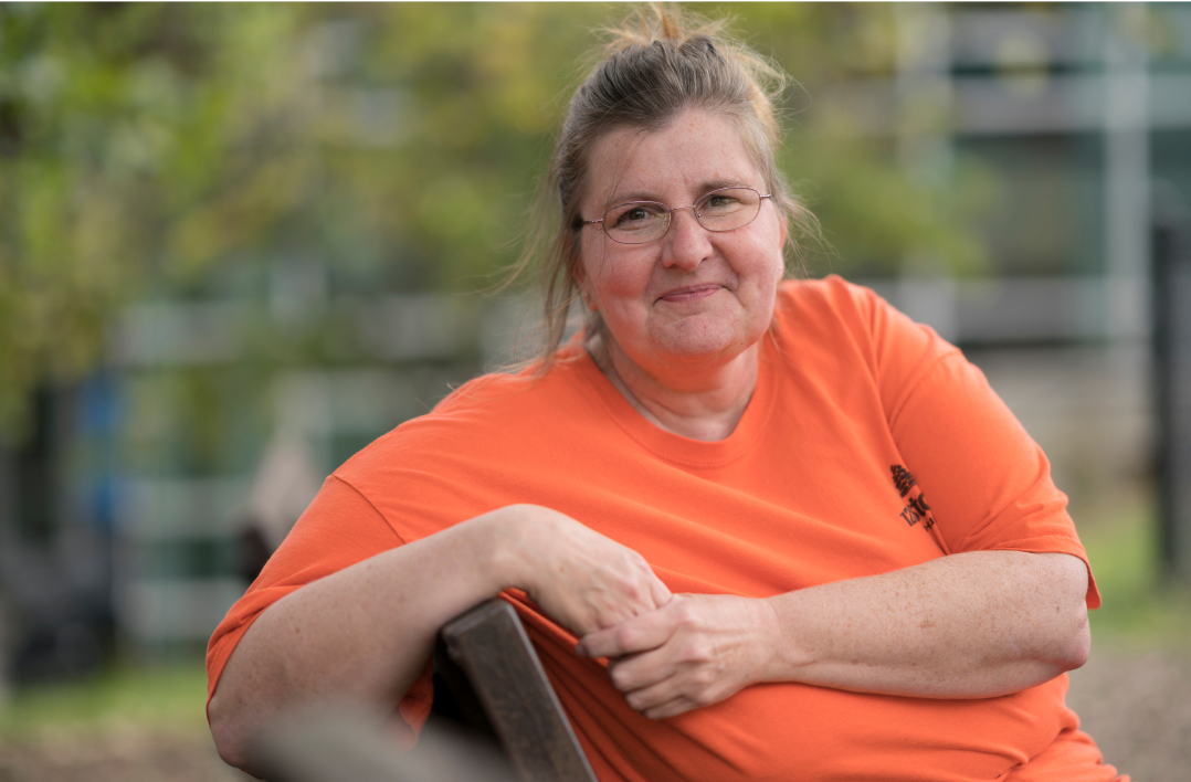 woman at Restoration House sitting on a bench smiling