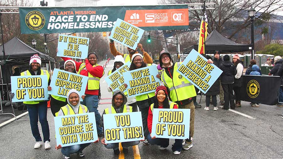Group of volunteers holding signs with encouraging phrases