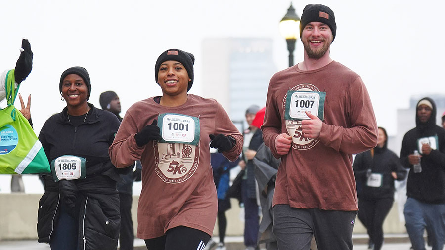 People running in race and smiling at camera