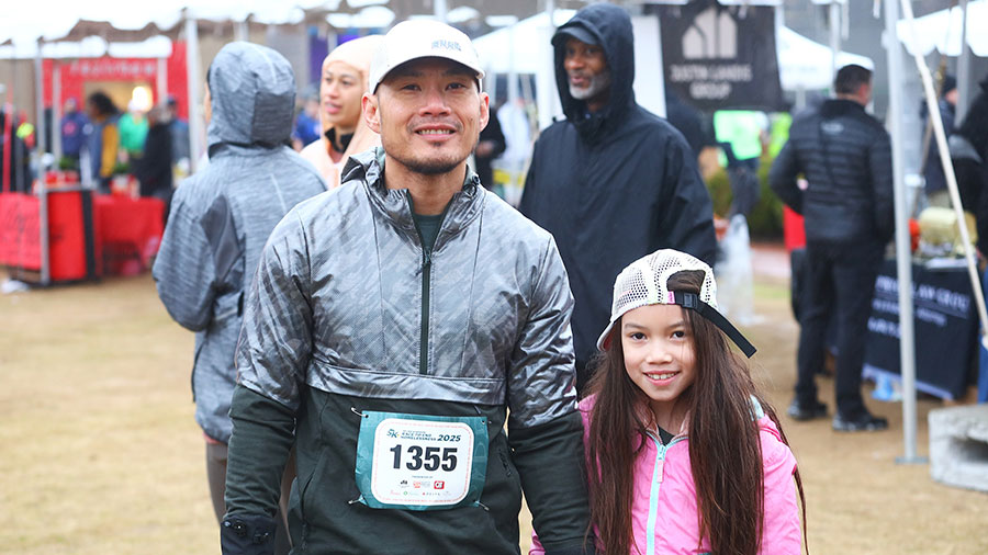 Father and daughter smiling at camera at race