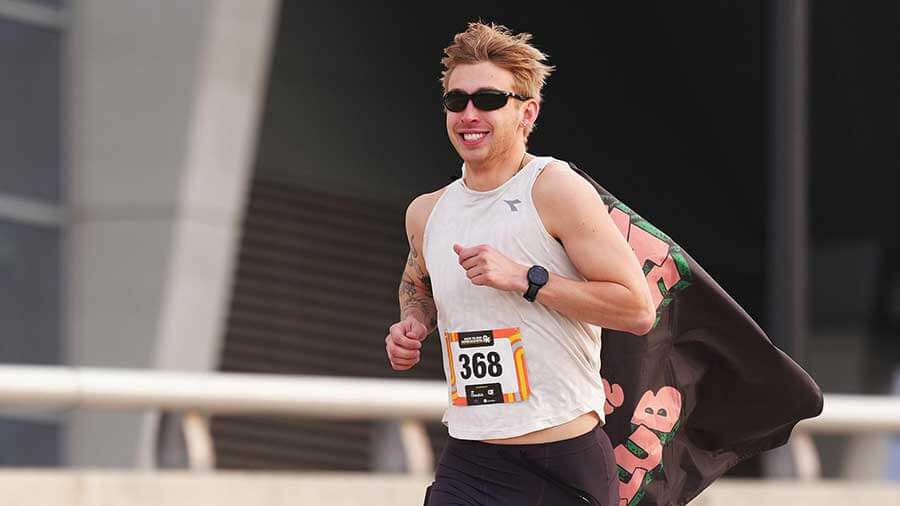 Man running the race wearing a cape