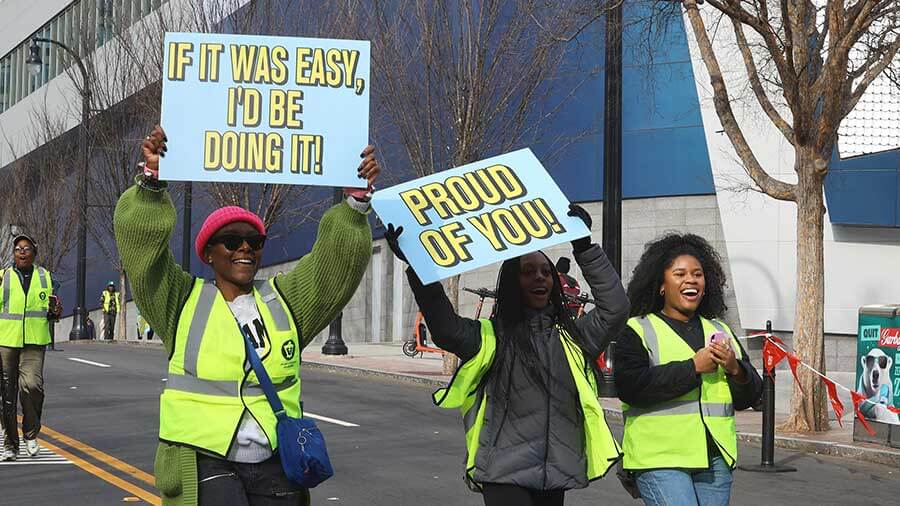 Volunteers holding signs encouraging runners